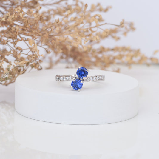 Silver ring with two sapphires on a white round stone
